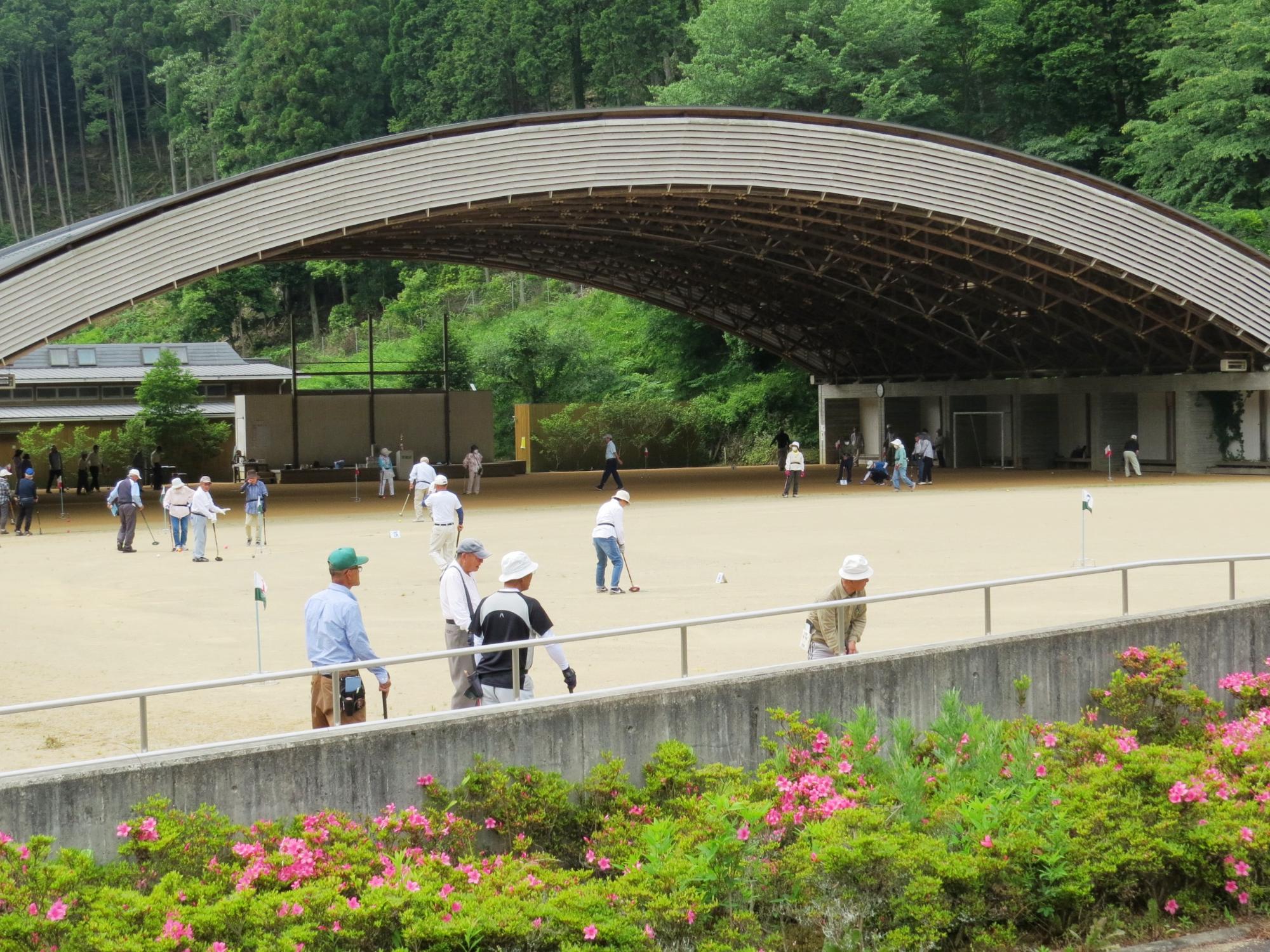 学遊館ゆうゆう広場で、グラウンドゴルフを楽しむプレイヤーらの写真