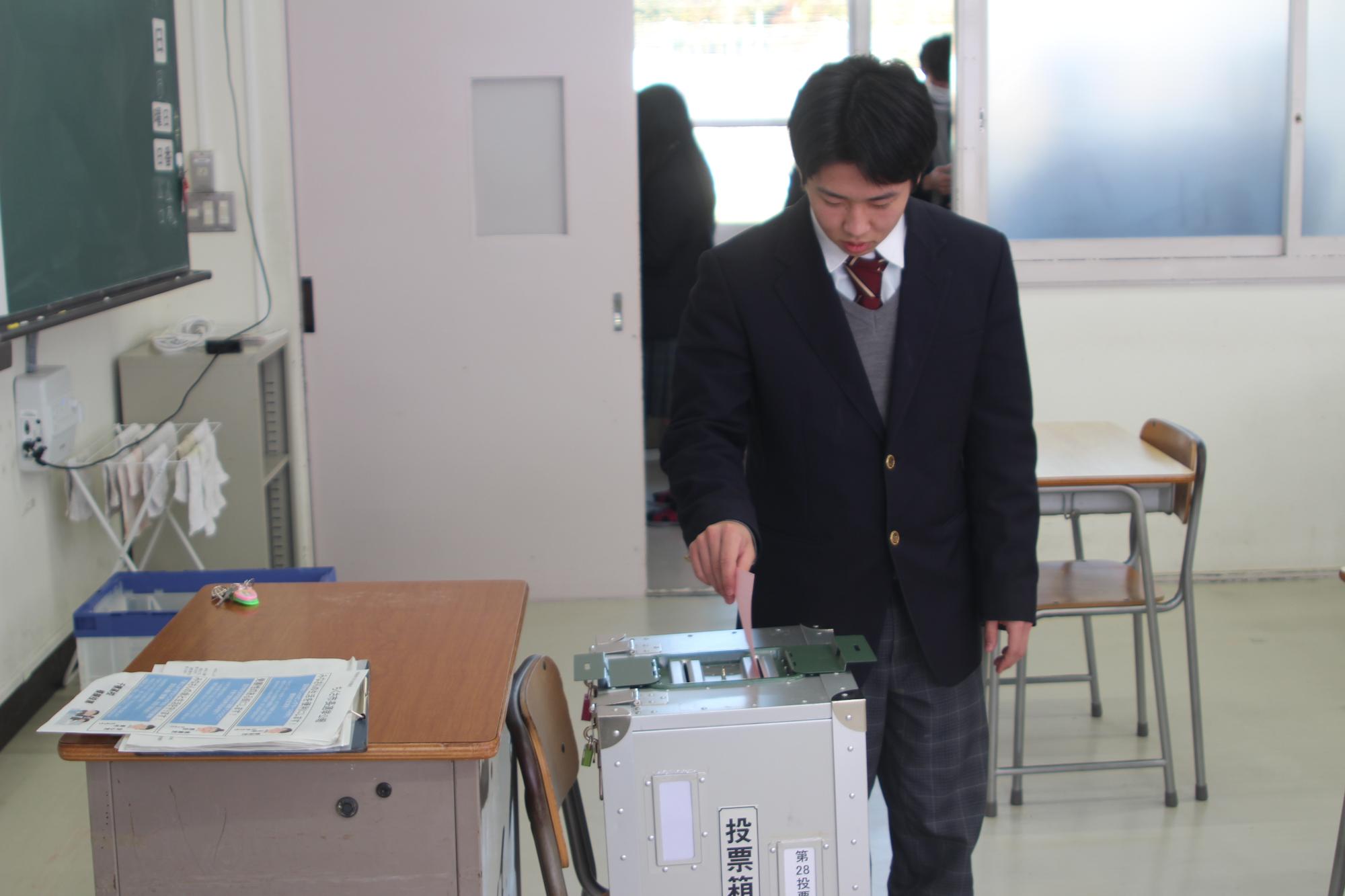 投票箱に用紙を入れる生徒