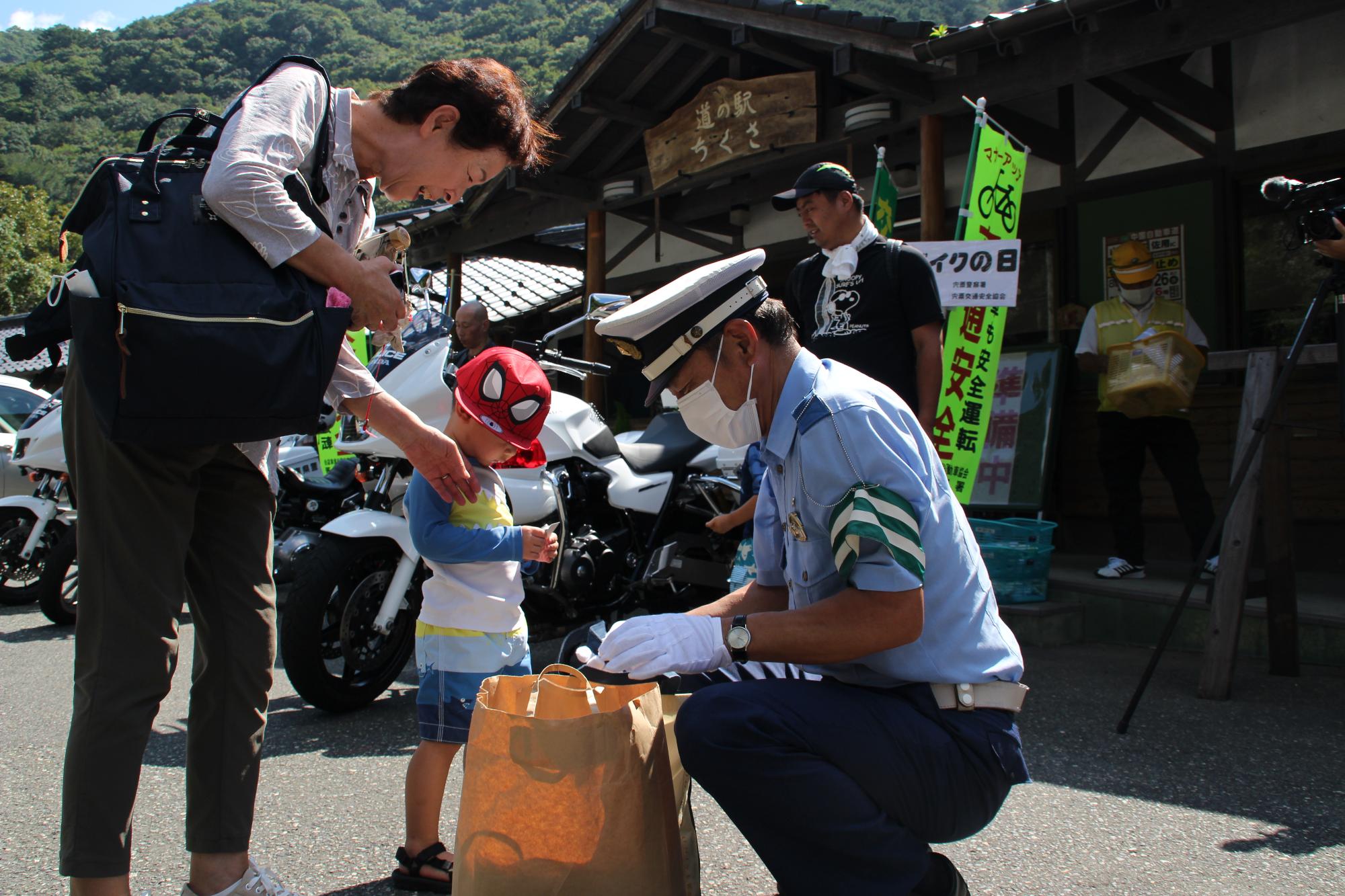 警察官から缶バッチをもらう男の子の写真