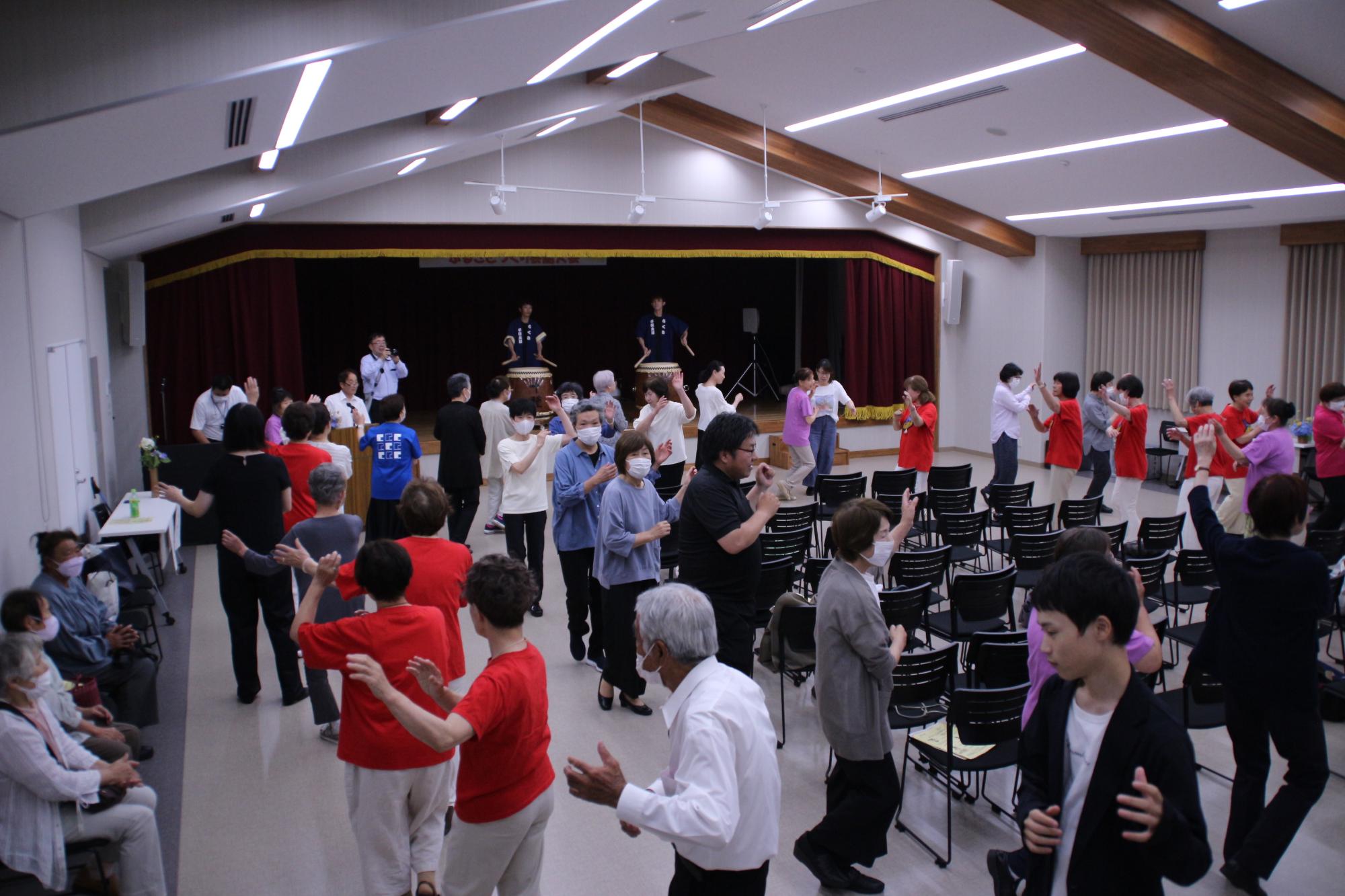 出演団体の演目終了後に、会場にいる全員でしゃんとこを踊っている写真