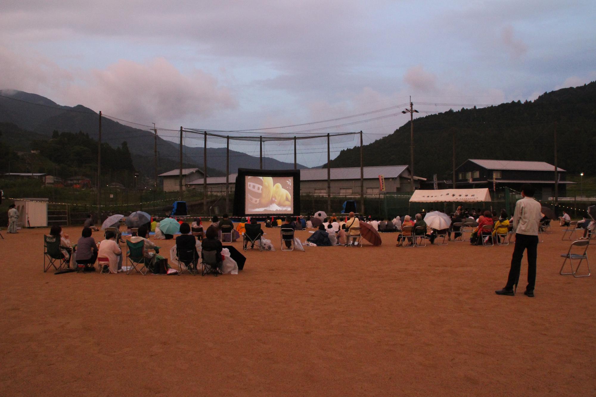 夕暮れどきに野外で上映された映画祭の会場の写真