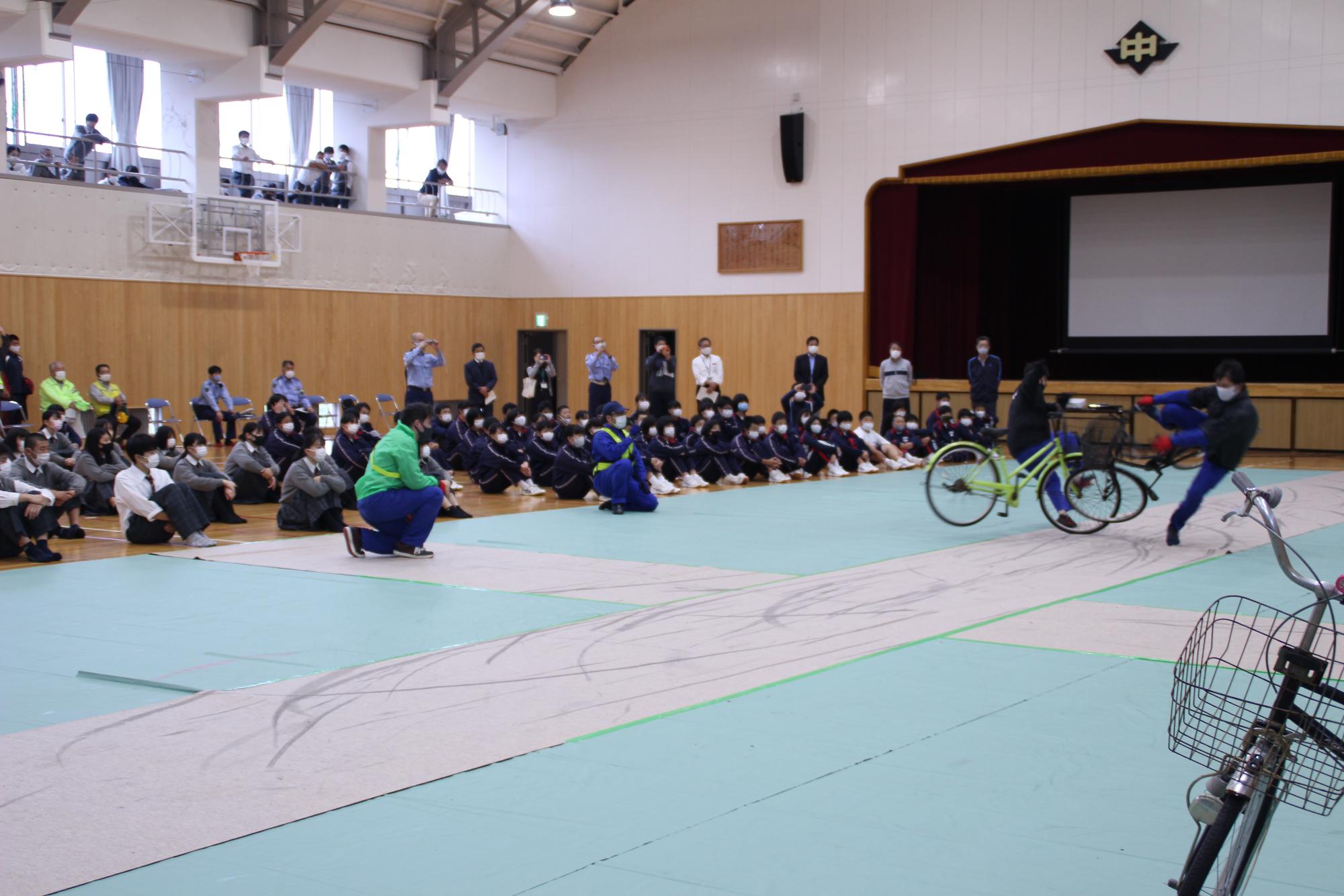 スタントマンが自転車に乗り自転車同士の接触を実演する様子