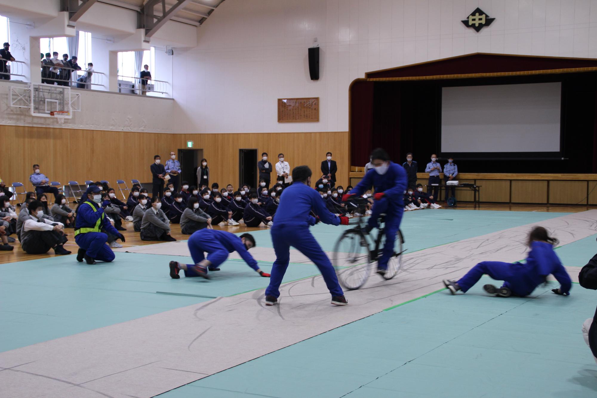 自転車と人との接触事故を実演するスタントマンの写真