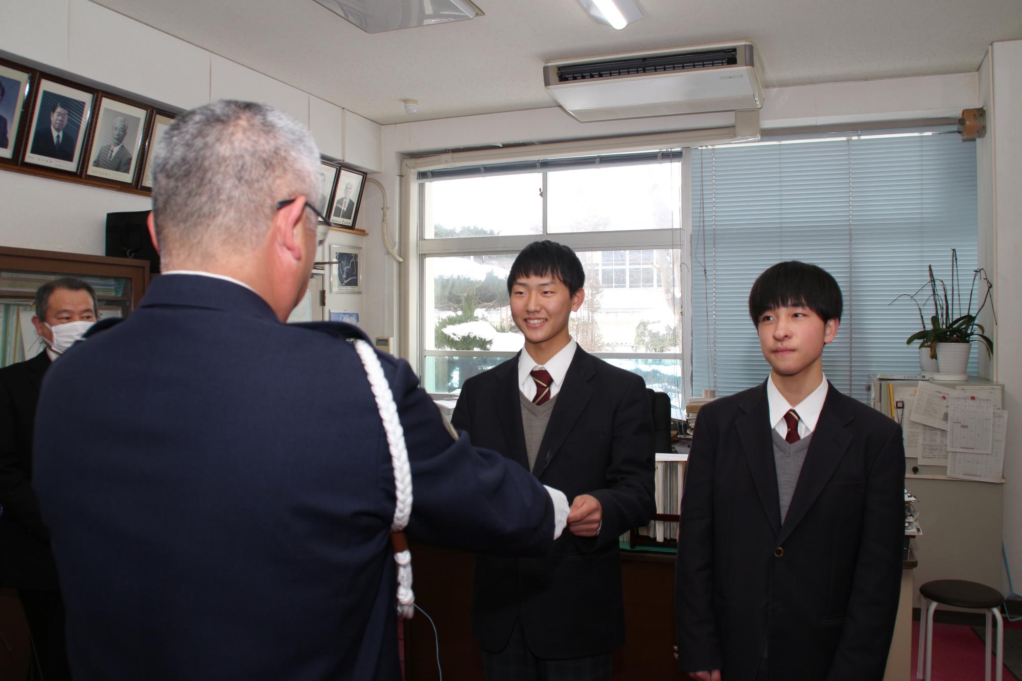 千種高校の生徒代表の赤染さんが、西藤県警交通企画課調査官から表彰状を授与されている写真