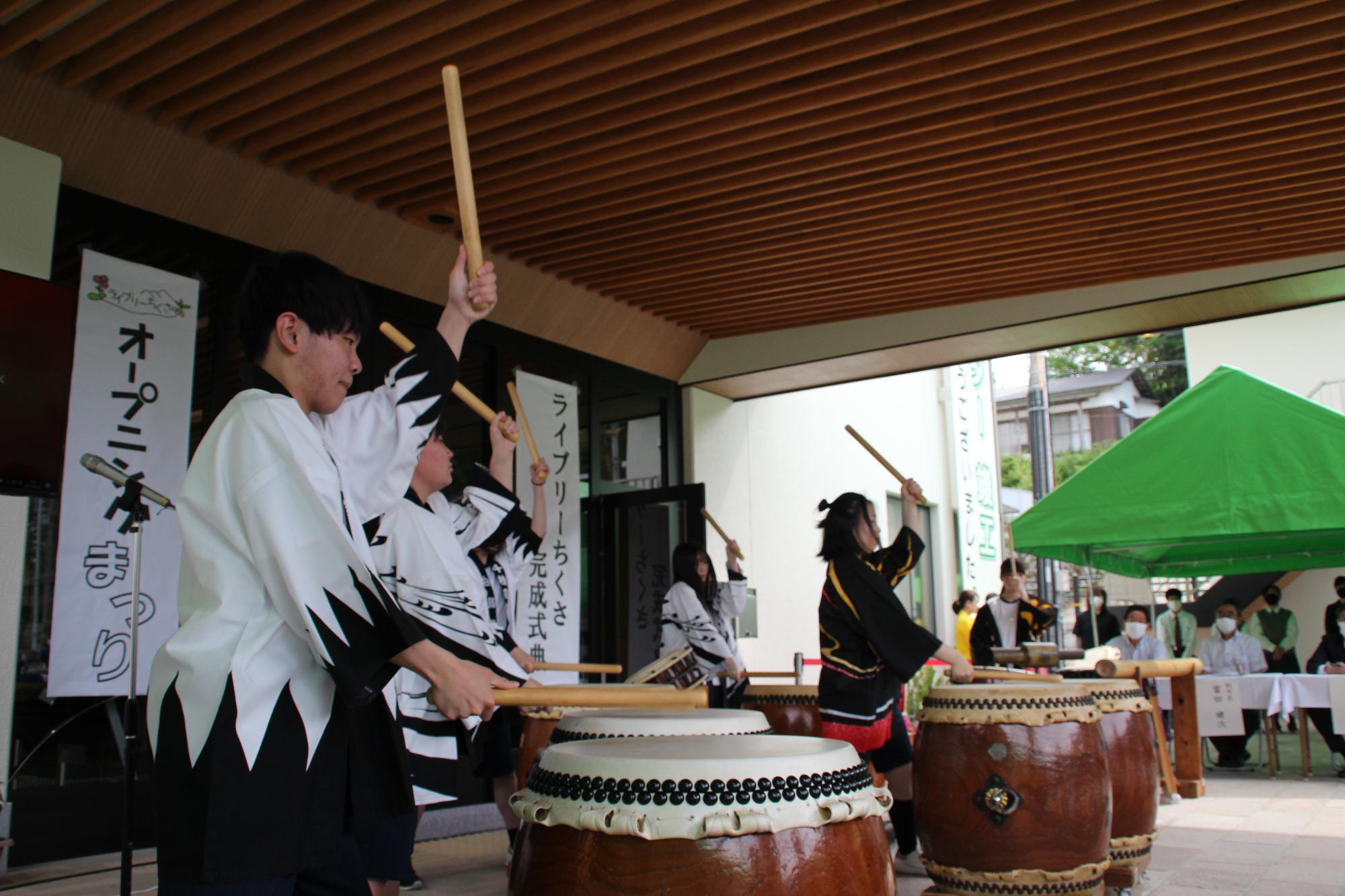 式典前に千種高校カルチャー部がライブリーちくさの玄関前で和太鼓を演奏している写真