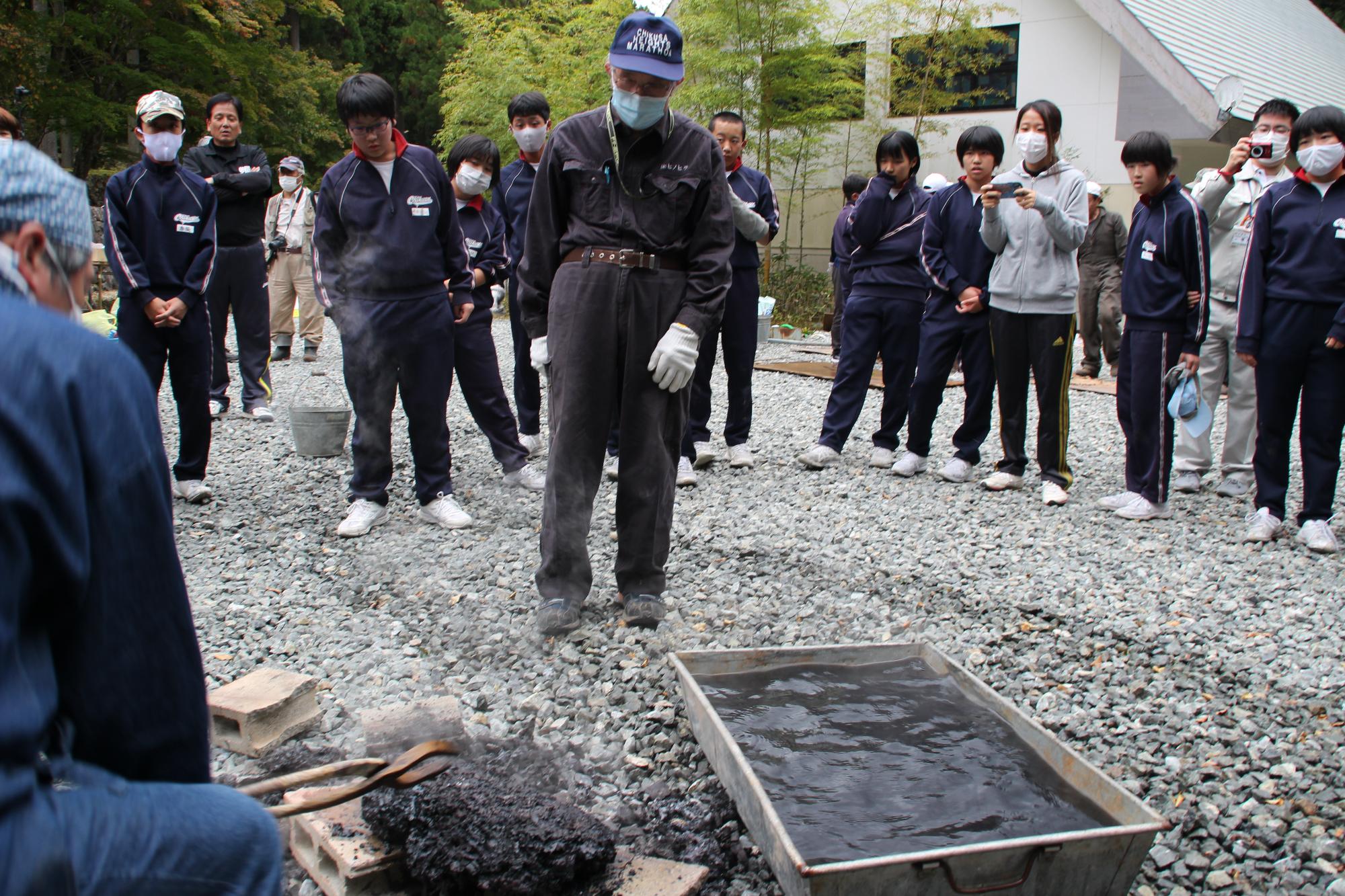 溶鉱炉から取り出したケラを貯めていた水につけて温度を下げている写真