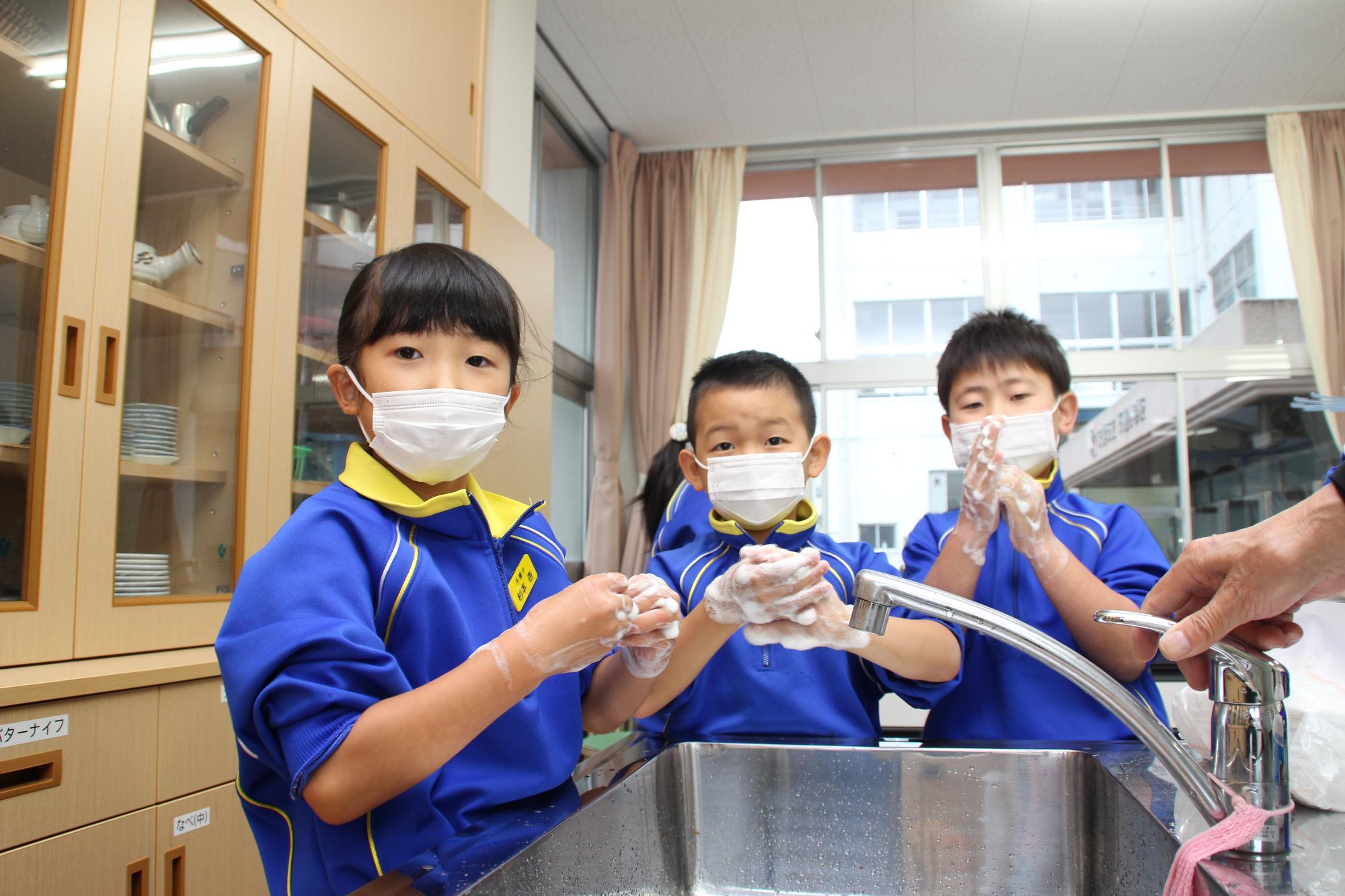 汚れが確認出来た部分を重点的に手洗いをする小学生の写真