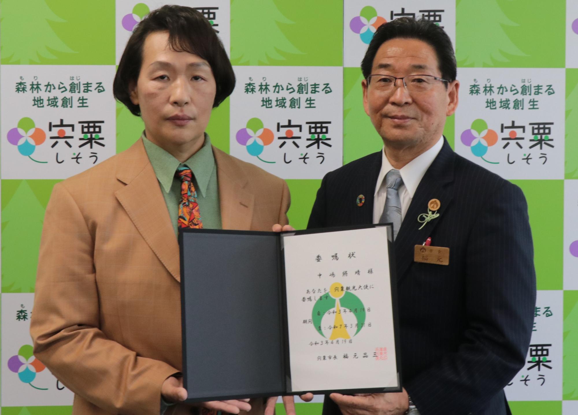 観光大使委嘱状を手にした左観光大使中嶋將晴さん右宍粟市長の写真