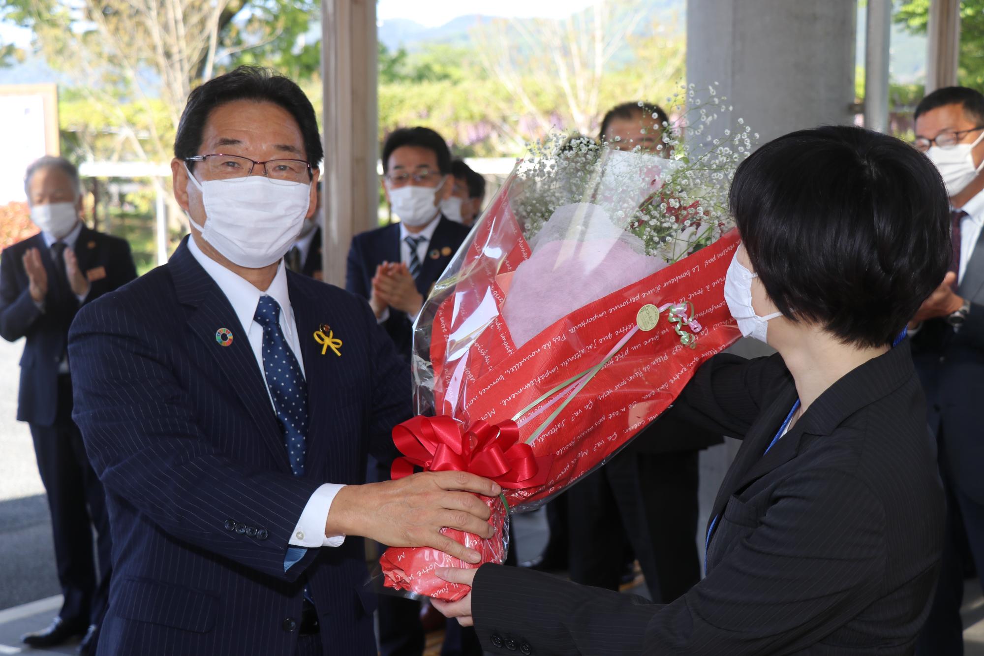 福元市長3期目初登庁、左に花束を手にした福元市長、右に花束を手渡す市職員の写真