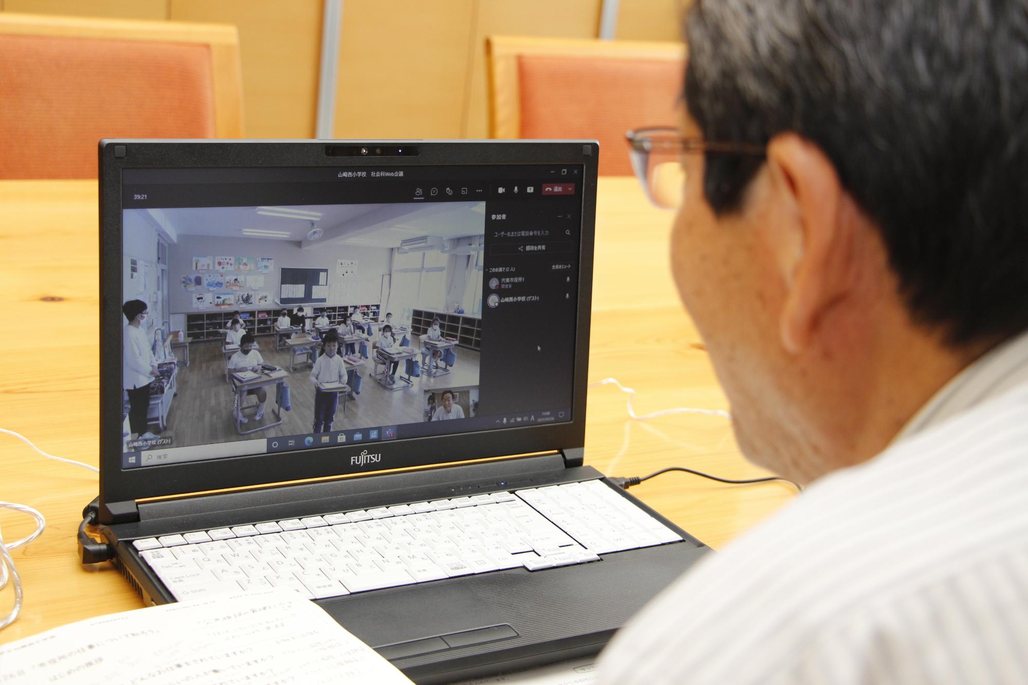 パソコンを前に山崎西小学校社会科オンライン授業を行っている福元市長の写真