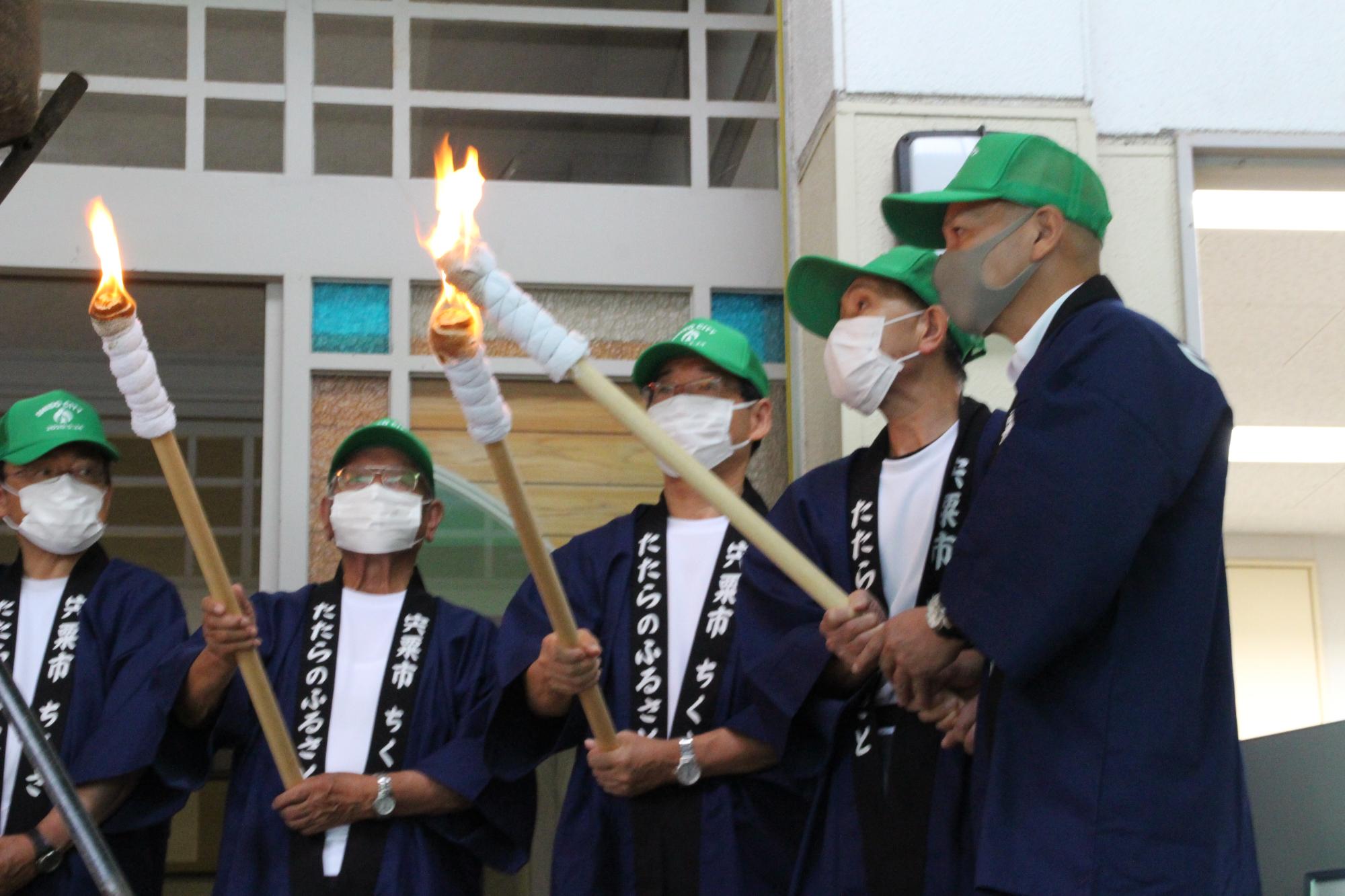 トーチキスで宍粟たたら製鉄の火をつなぐ福元市長らの写真