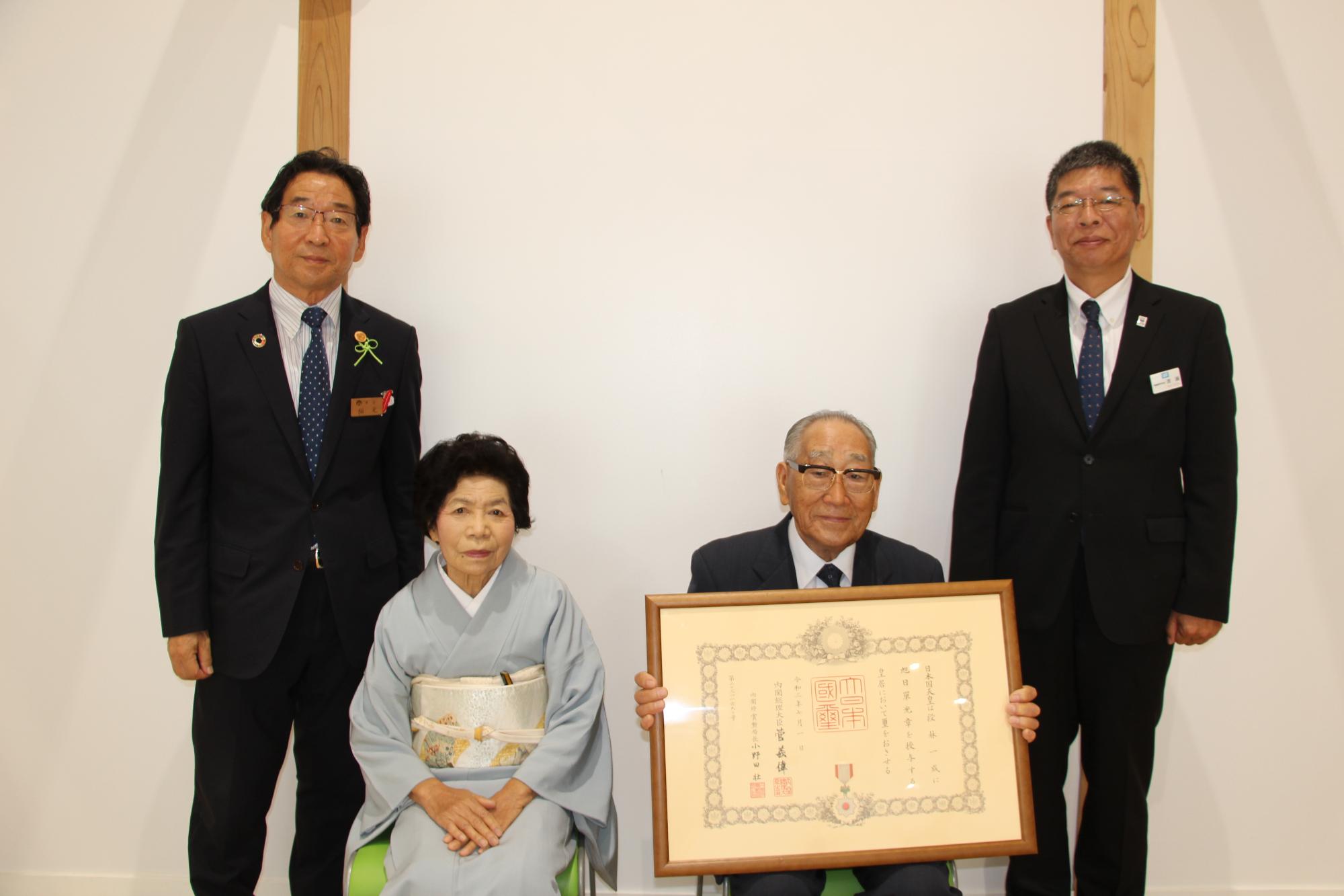 左は福元市長、中は勲記を手にした段林さんご夫妻、右は兵庫県西播磨県民局長が並んでいる写真
