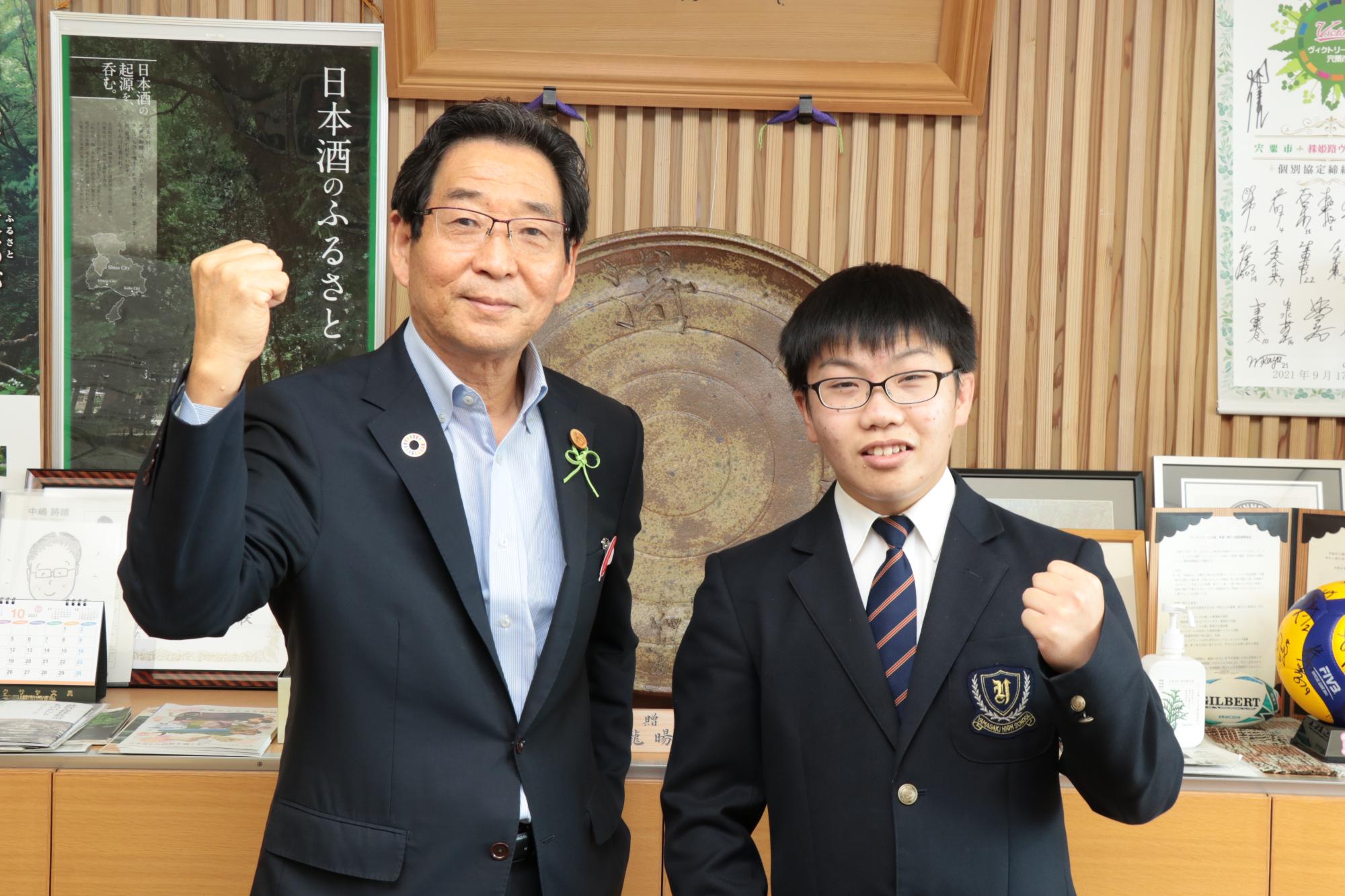 左は福元市長、右は山崎高校3年の西村さんがガッツポーズをしている写真
