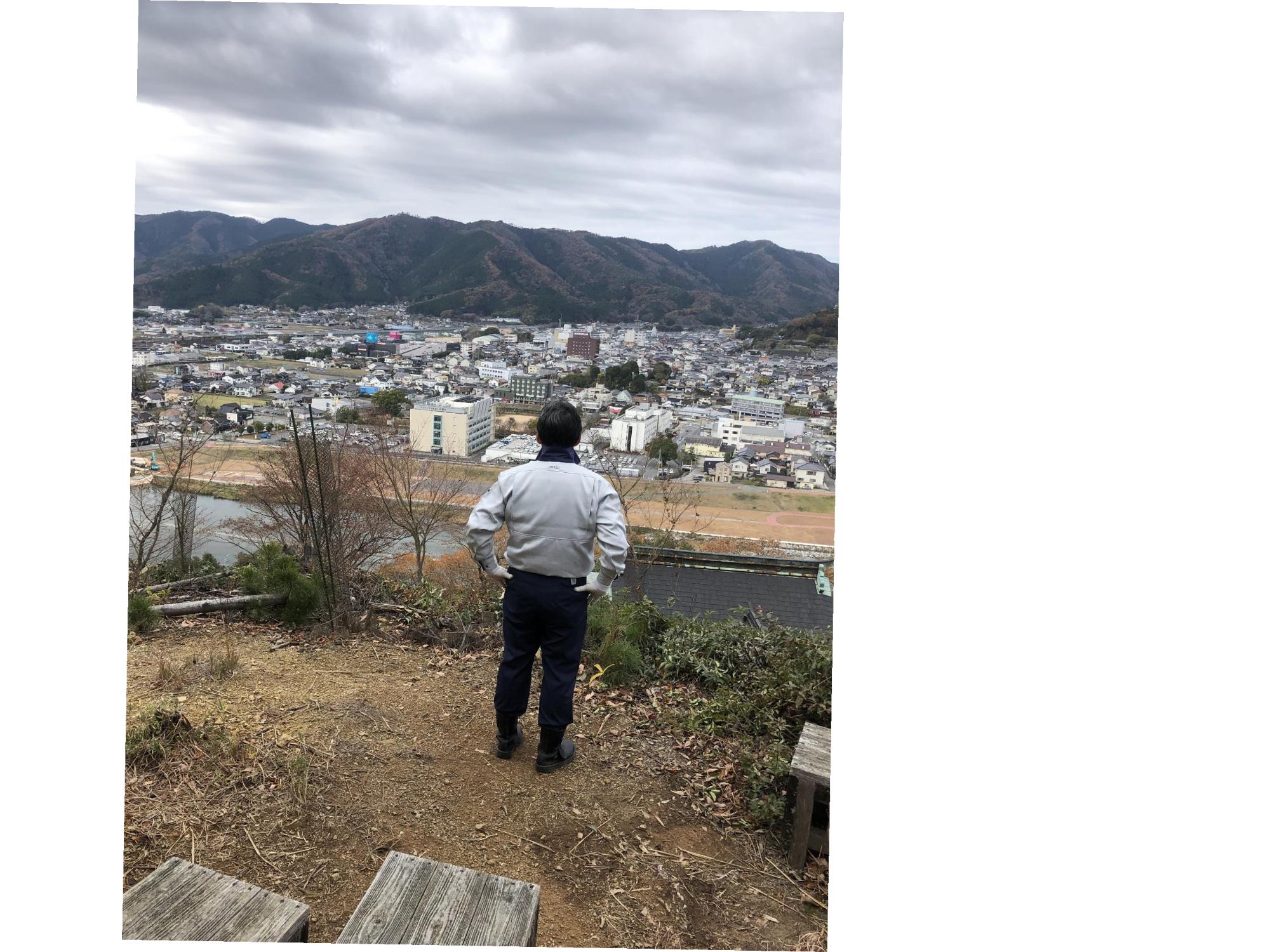 愛宕山の山頂から市の風景を眺めている福元市長の写真