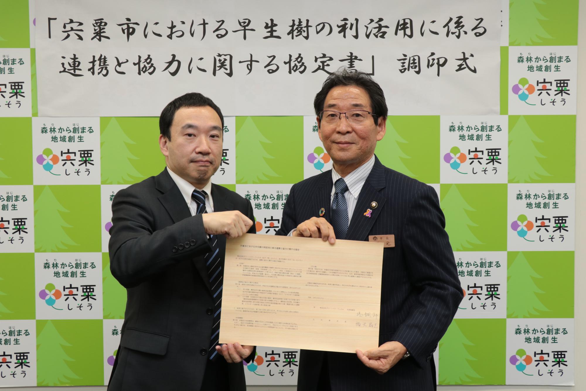 協定書を手にした、左は大阪ガス子会社の揚代表取締役、右は福元市長が並んでいる写真
