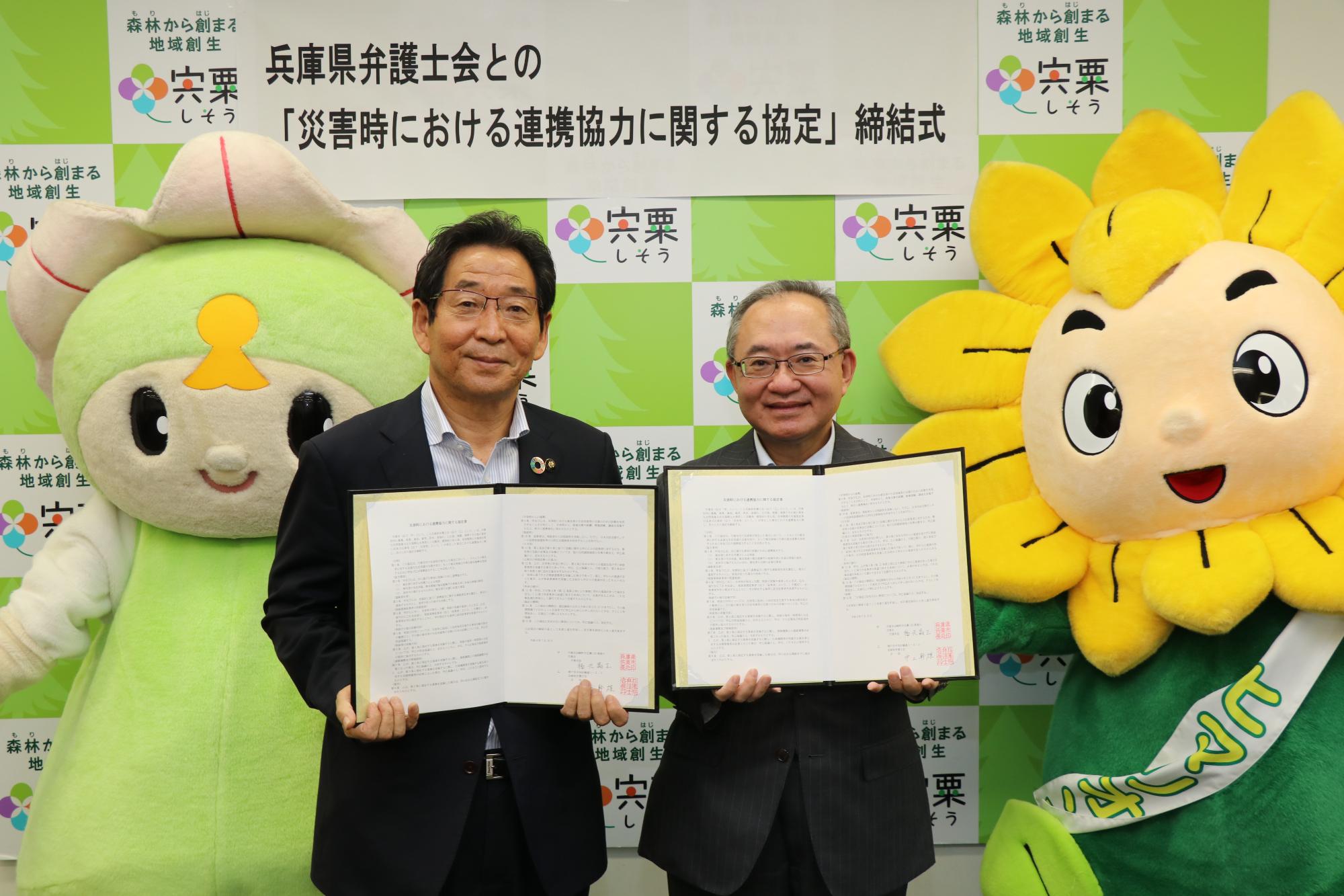 右、兵庫県弁護士会様と左、福元市長が協定書を手に並んでいる写真
