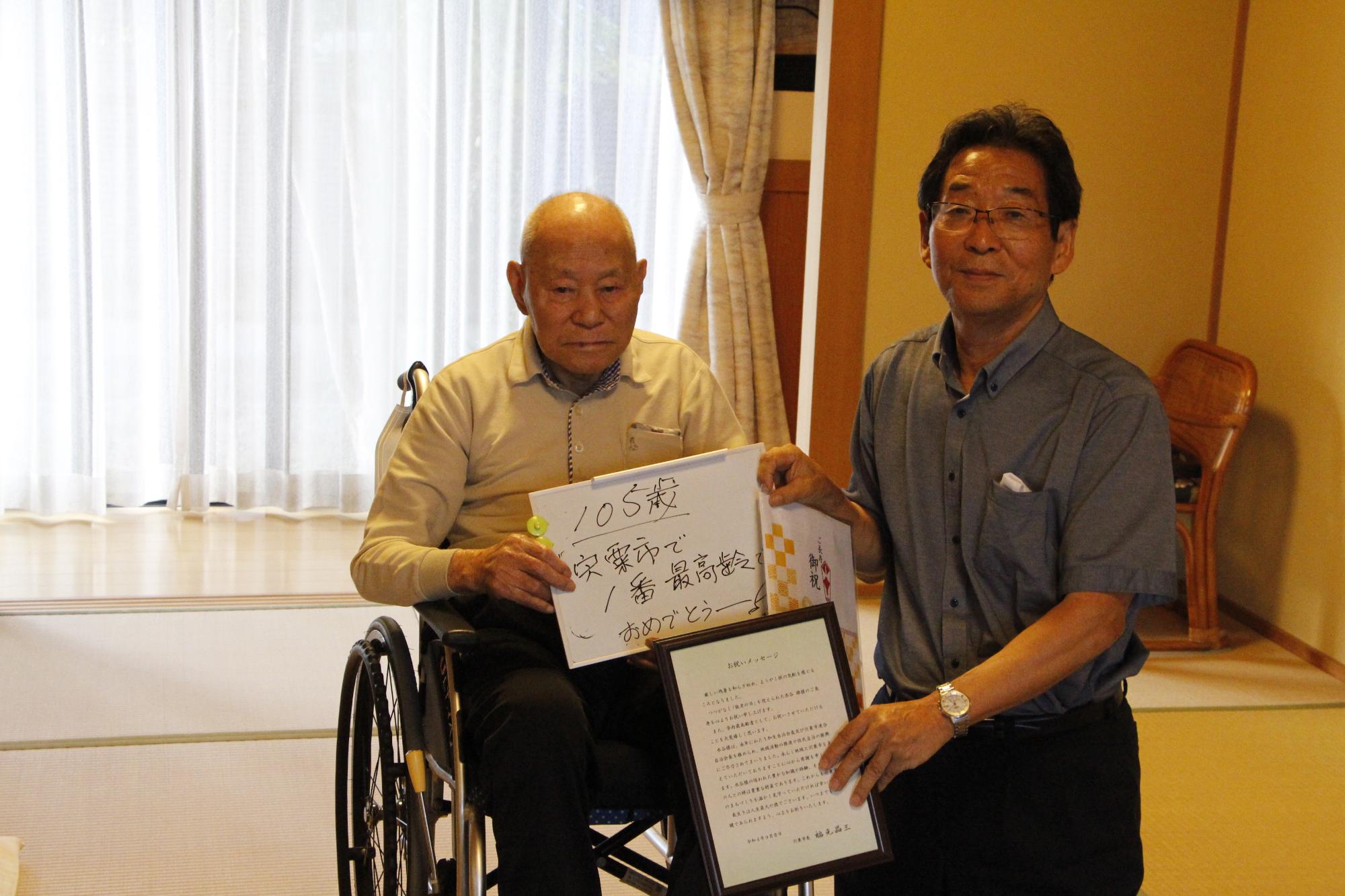 市内最高齢者を訪問し長寿のお祝いを述べる福元市長の写真