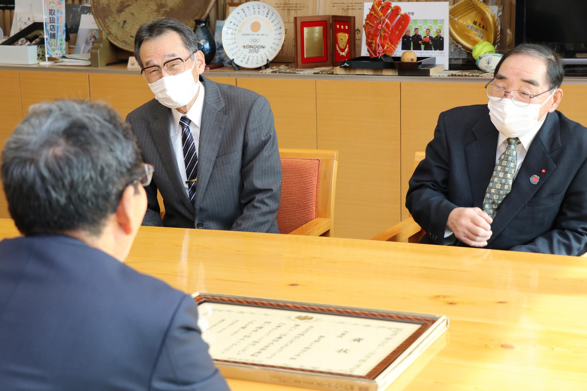 飯見夢むら棚田の会の岡田会長と大柿さんから農林水産大臣賞受賞報告を福元市長が受けている写真