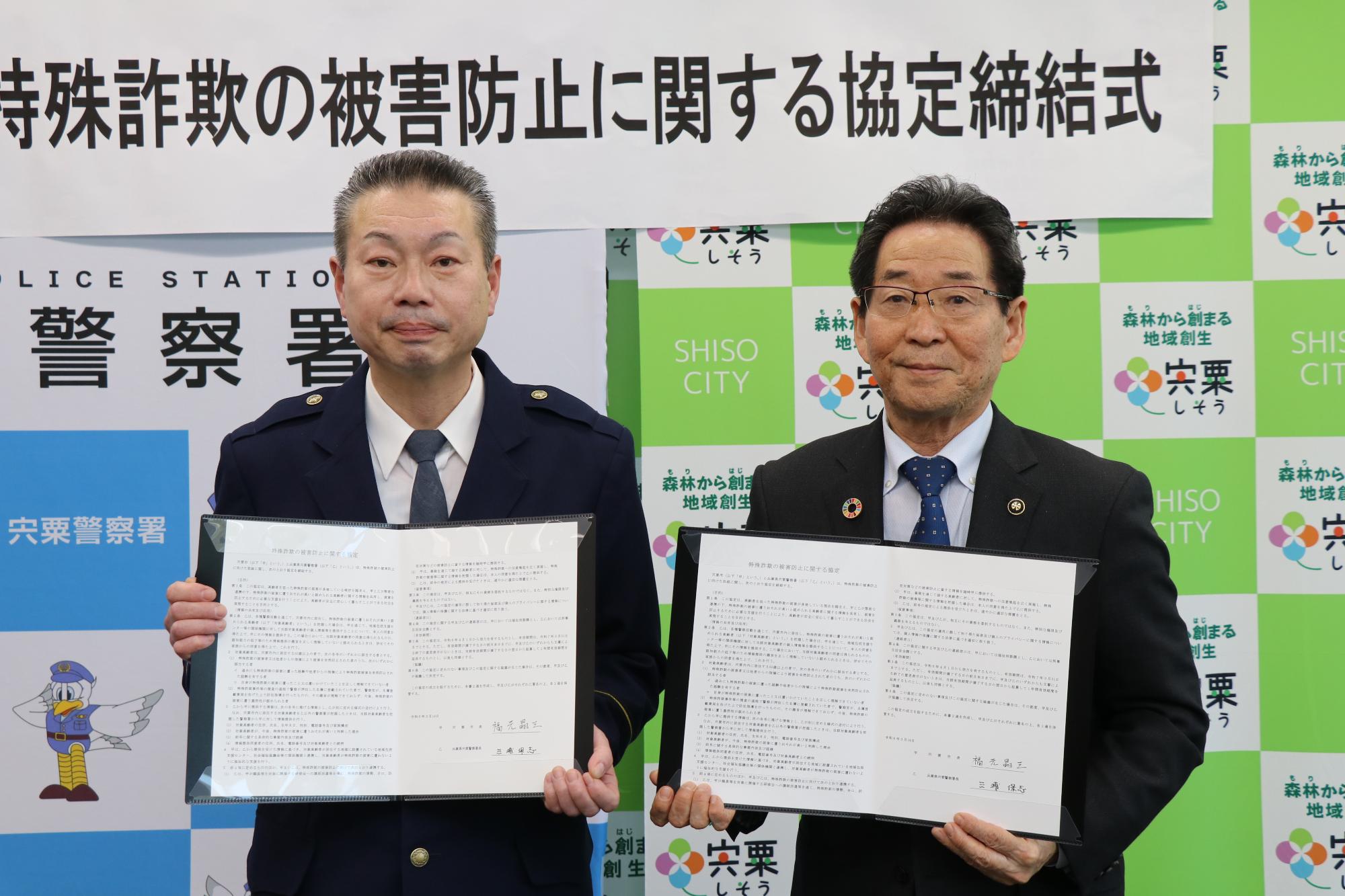 宍粟警察の三浦署長と福元市長が締結した協定書をもって並んでいる写真