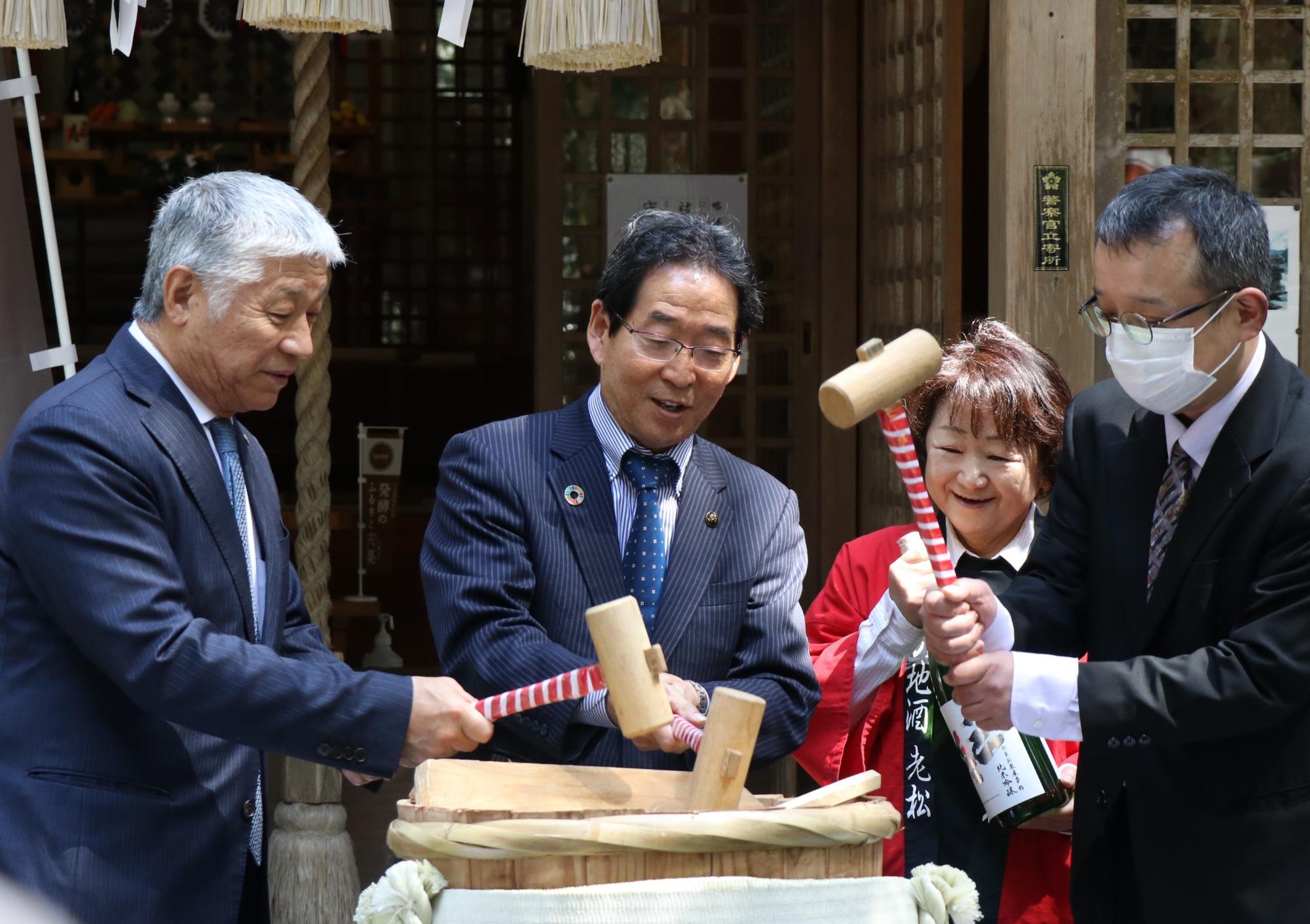 地酒「三笑」の蔵出式で福元市長と関係者らが鏡割りをしている写真