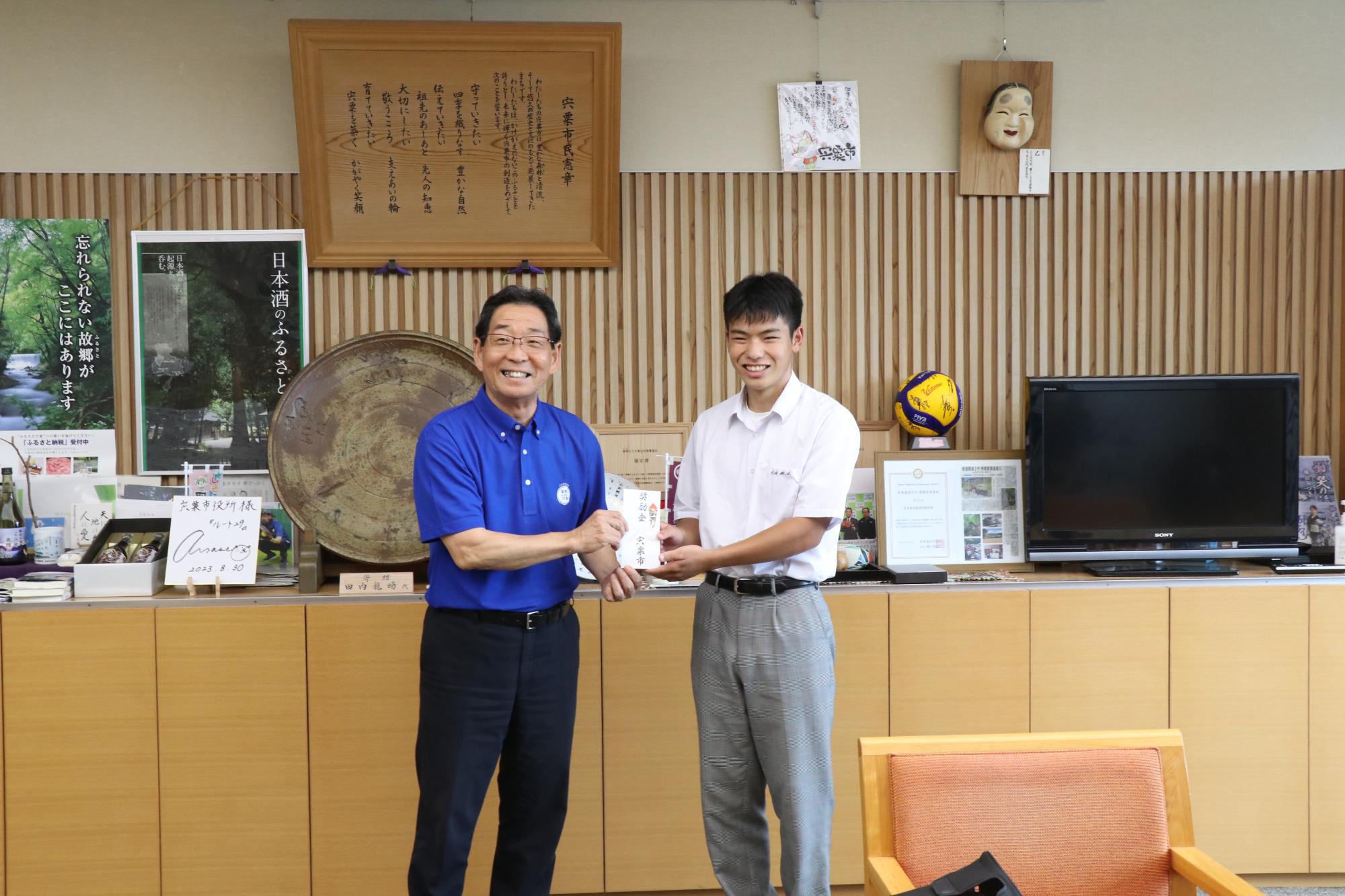 カヌー競技で優勝した梅原さんと並ぶ福元市長の写真