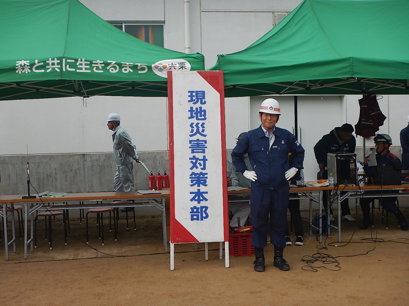 宍粟市総合防災訓練で災害対策本部の看板の近くに福元市長が立っている写真