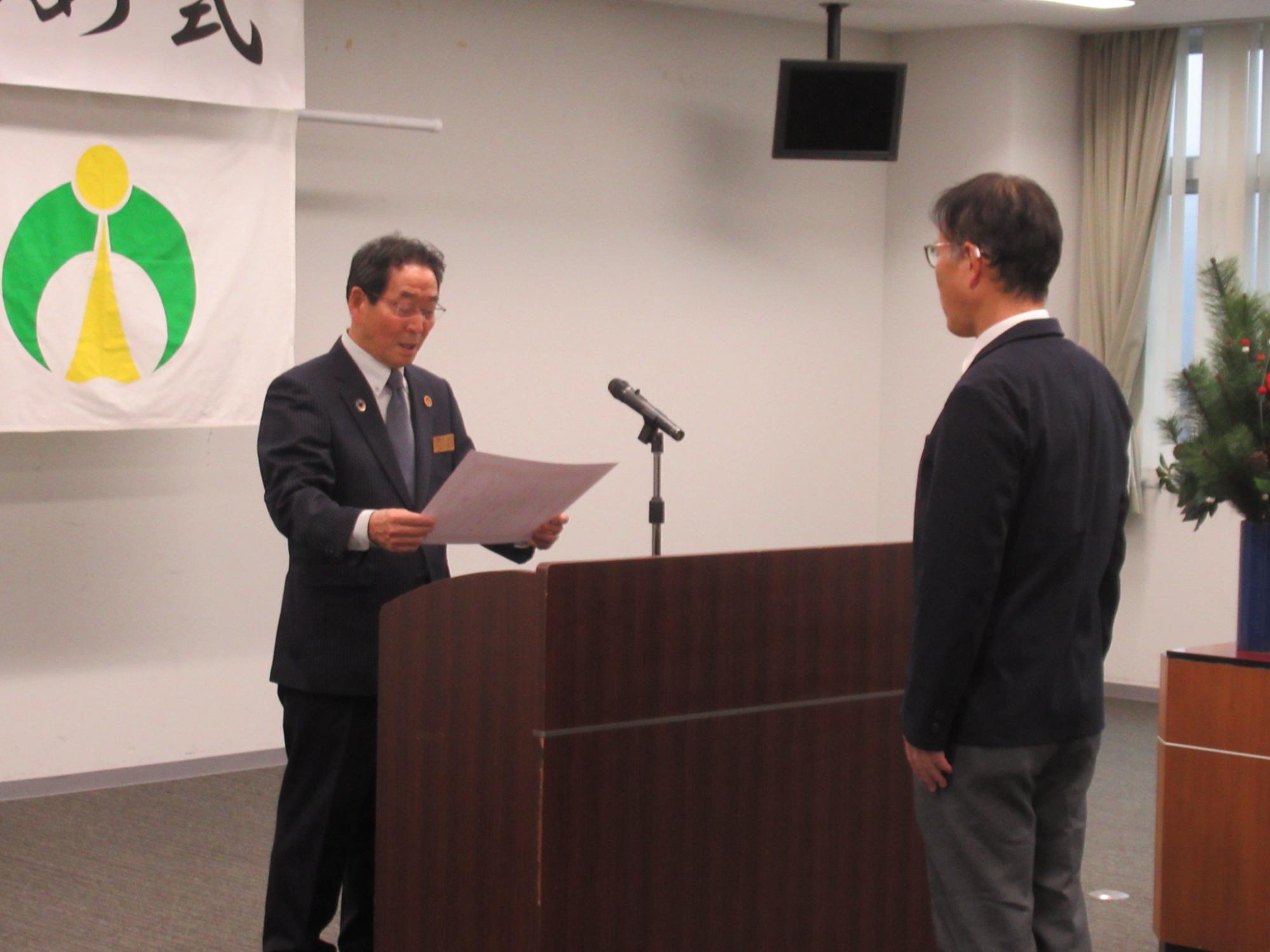 市長から表彰状を授与する市職員
