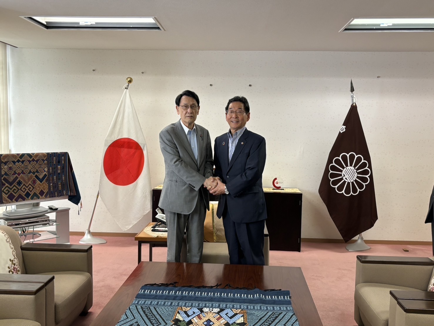 国会議員と握手をしている福元市長の写真