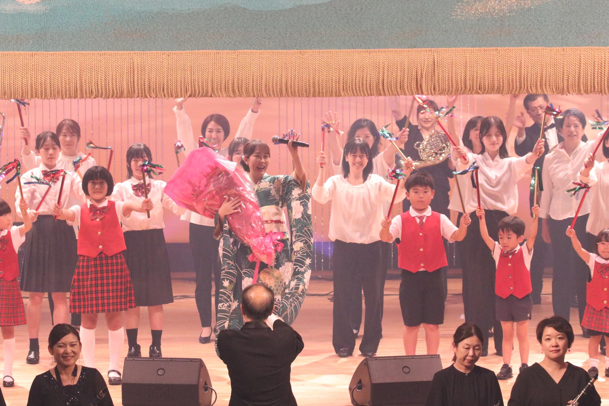 ステージ上で観客に応える丘みどりさんと宍粟市少年少女合唱団ファミリー