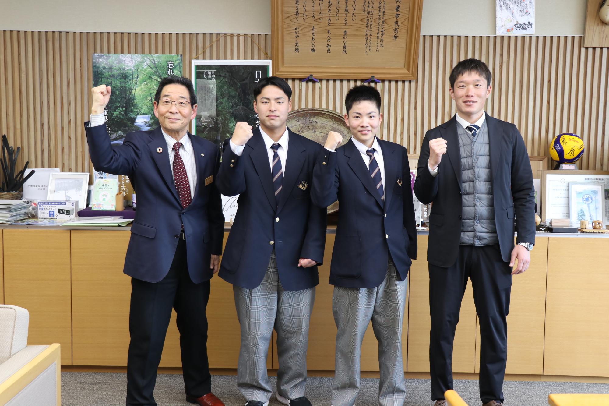 伊和高カヌー部の選手や先生が市長と並んで拳を挙げている写真