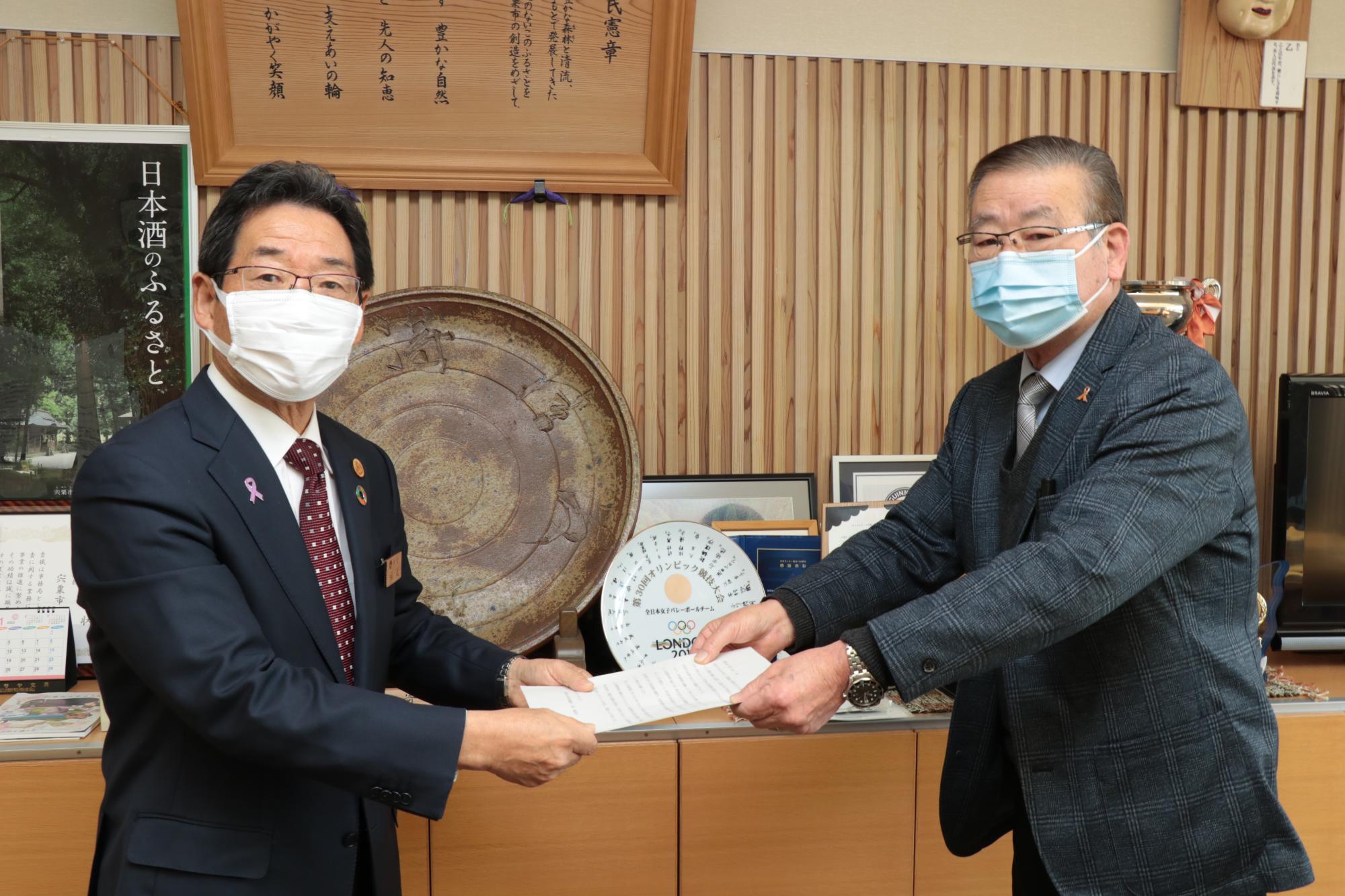 公共料金審議会の森脇会長から答申書を受け取る、右、福元市長の写真